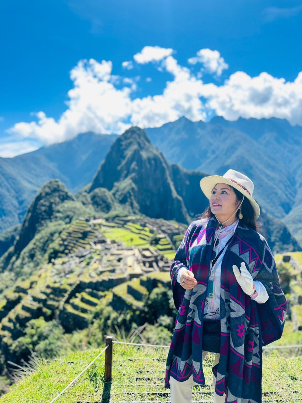 Pure baby alpaca shawl in navy with magenta and gray Andean geometric pattern, worn at Machu Picchu